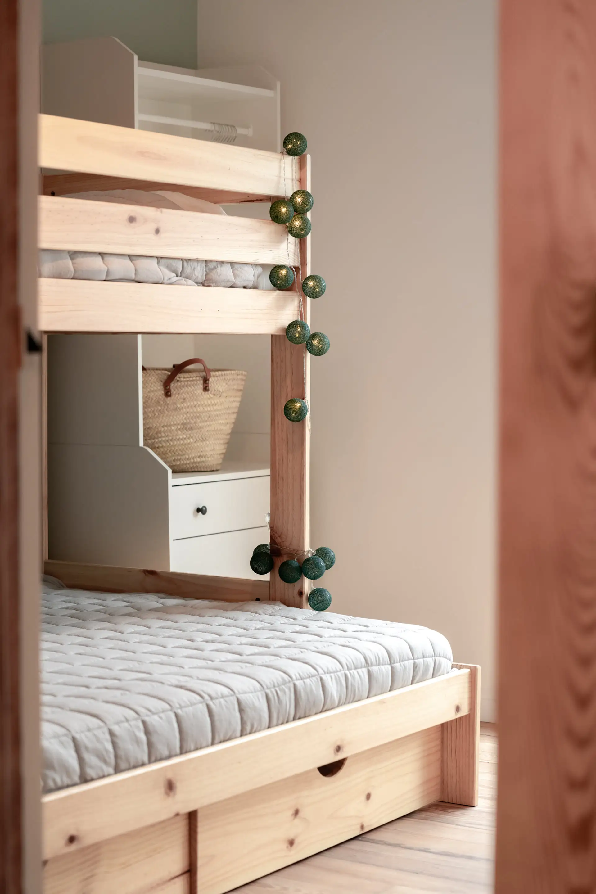 Lits superposés en bois avec tiroirs et plantes suspendues