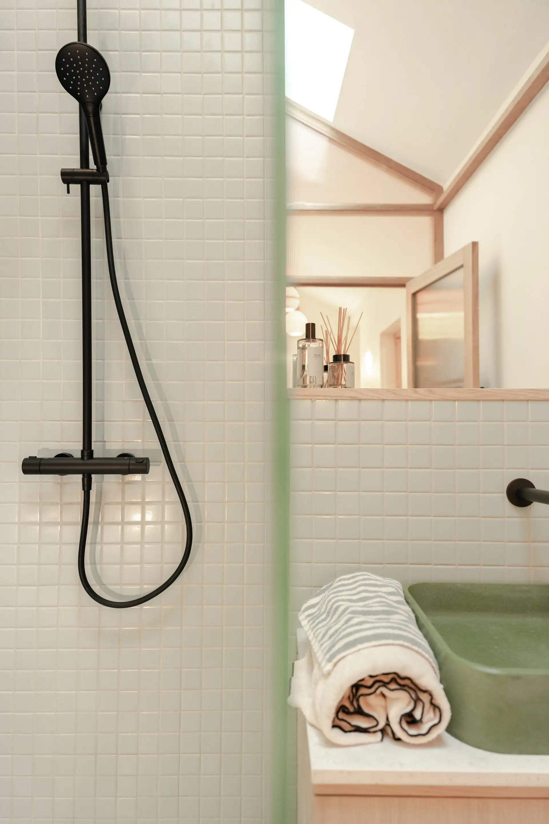 Douche noire et mosaïque, vasque en pierre et serviette