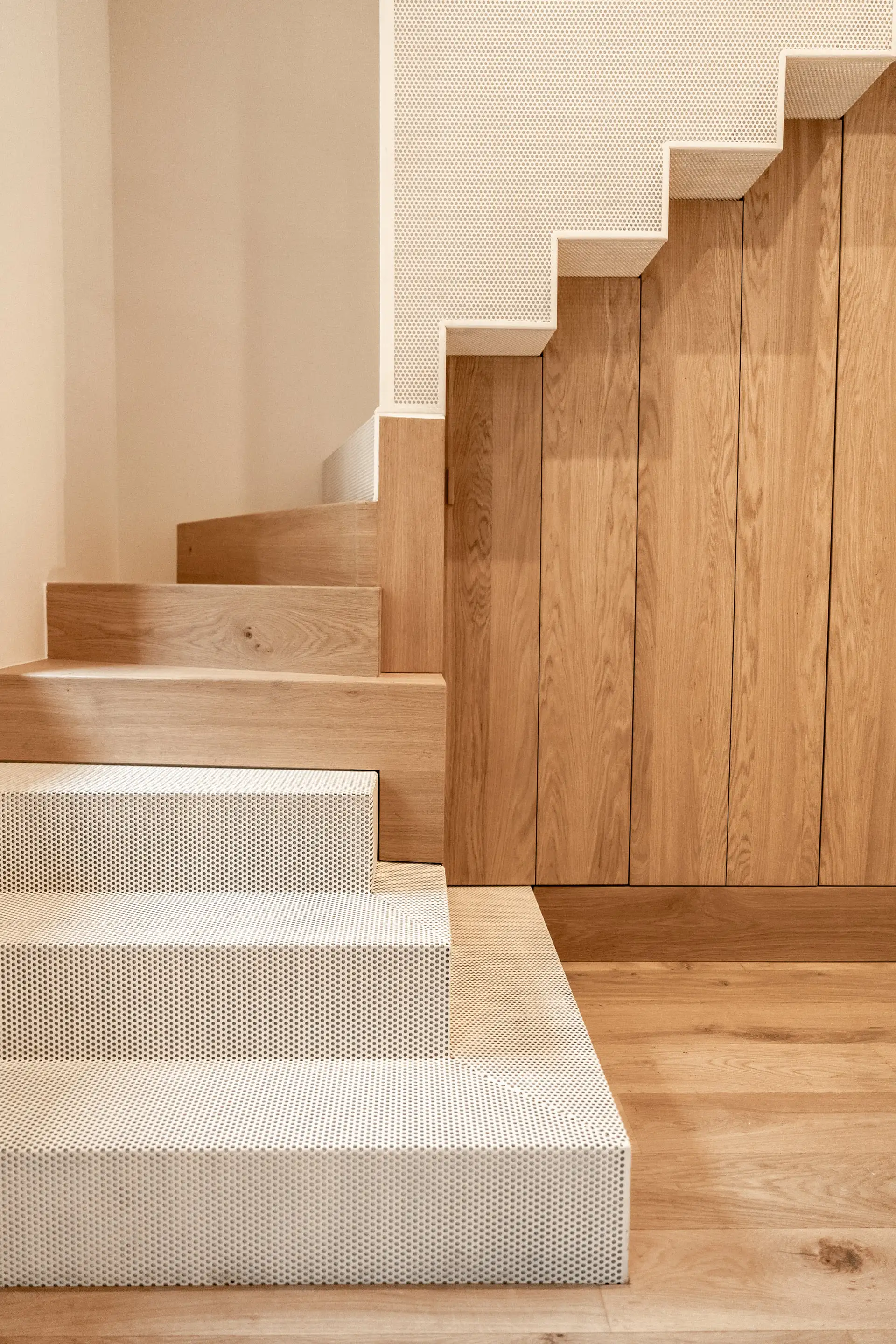 Escalier vu de côté, marches blanches et paroi en bois