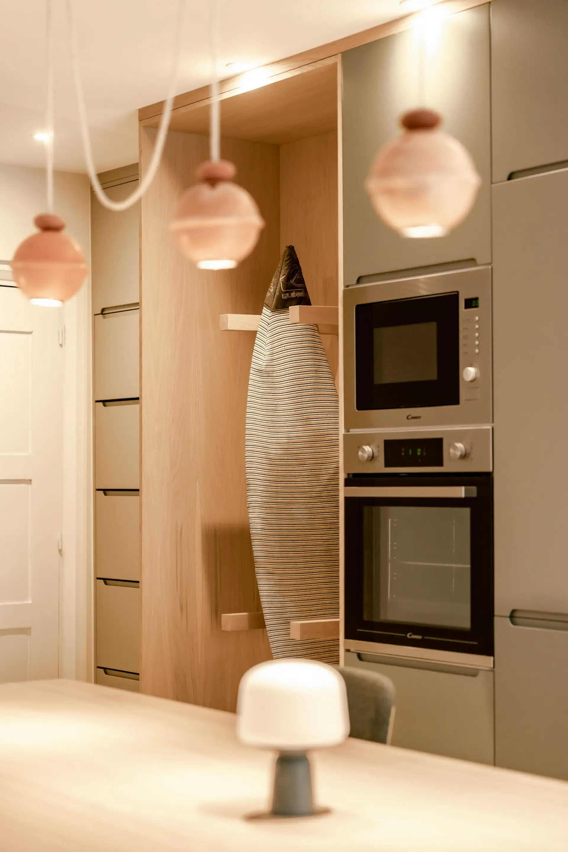 Cuisine encastrée dans un meuble en bois, suspensions en céramique