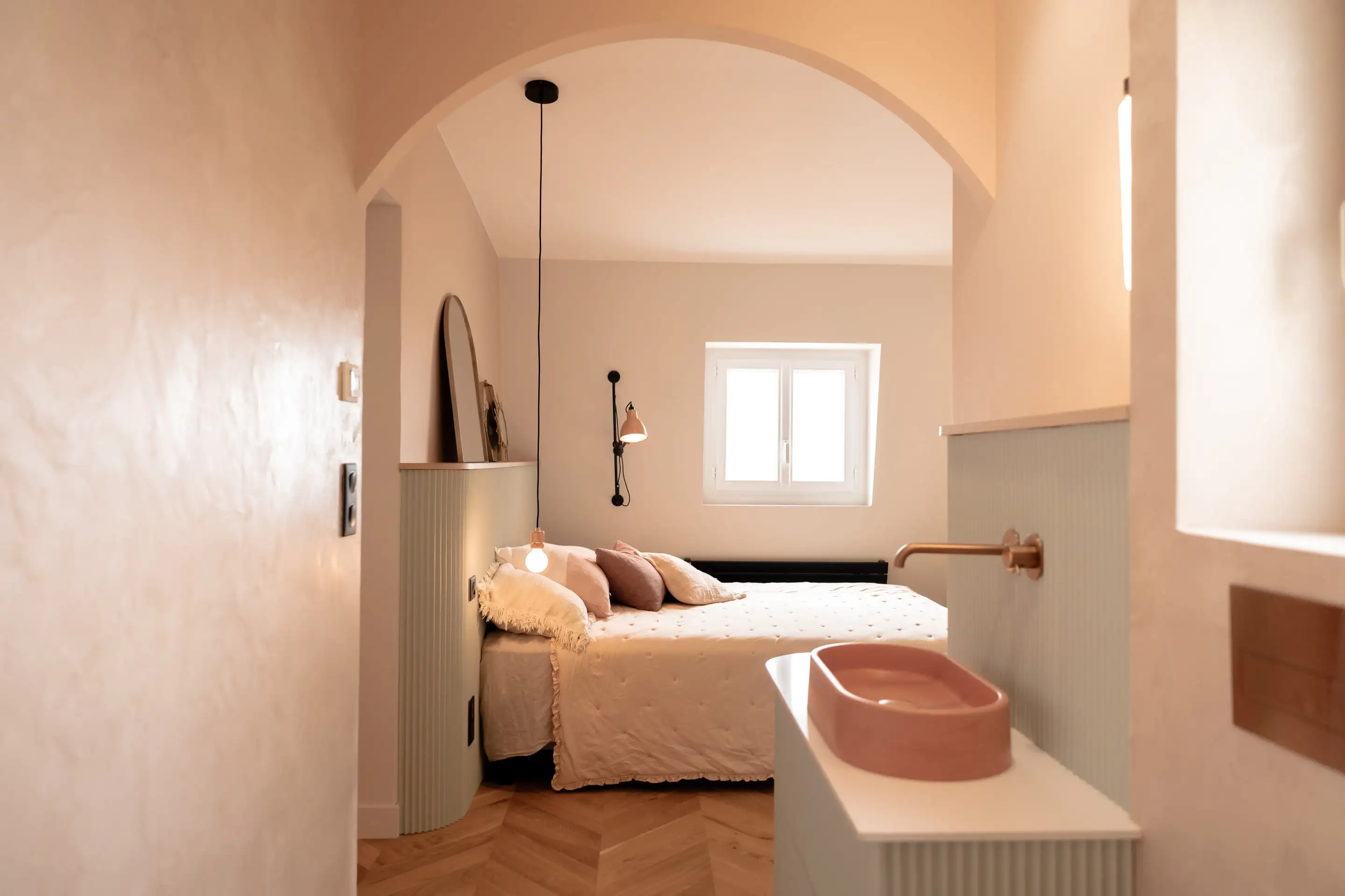 Chambre et salle d’eau en enfilade sous une arche enduite