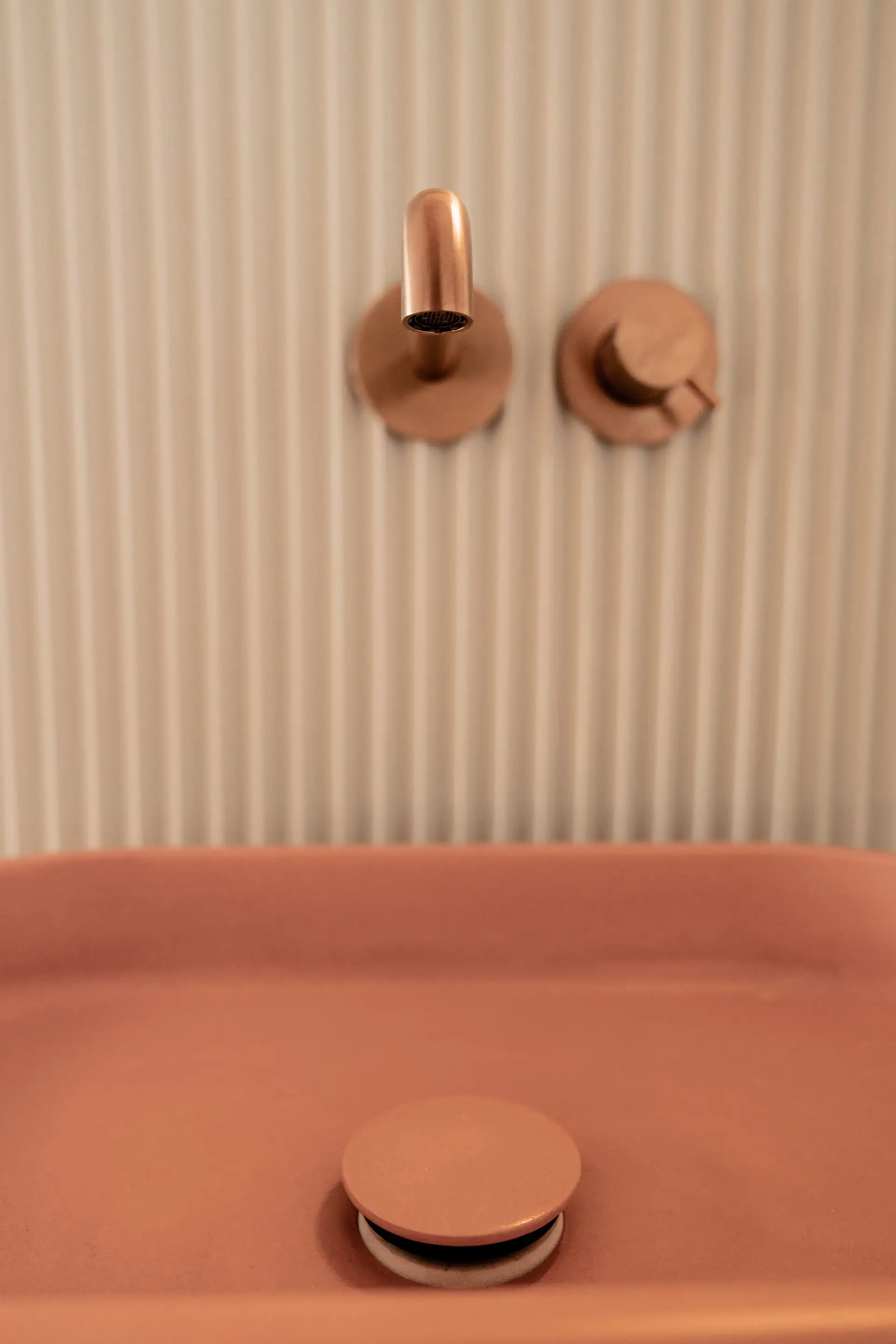 Mitigeurs cuivrés et vasque en béton rose