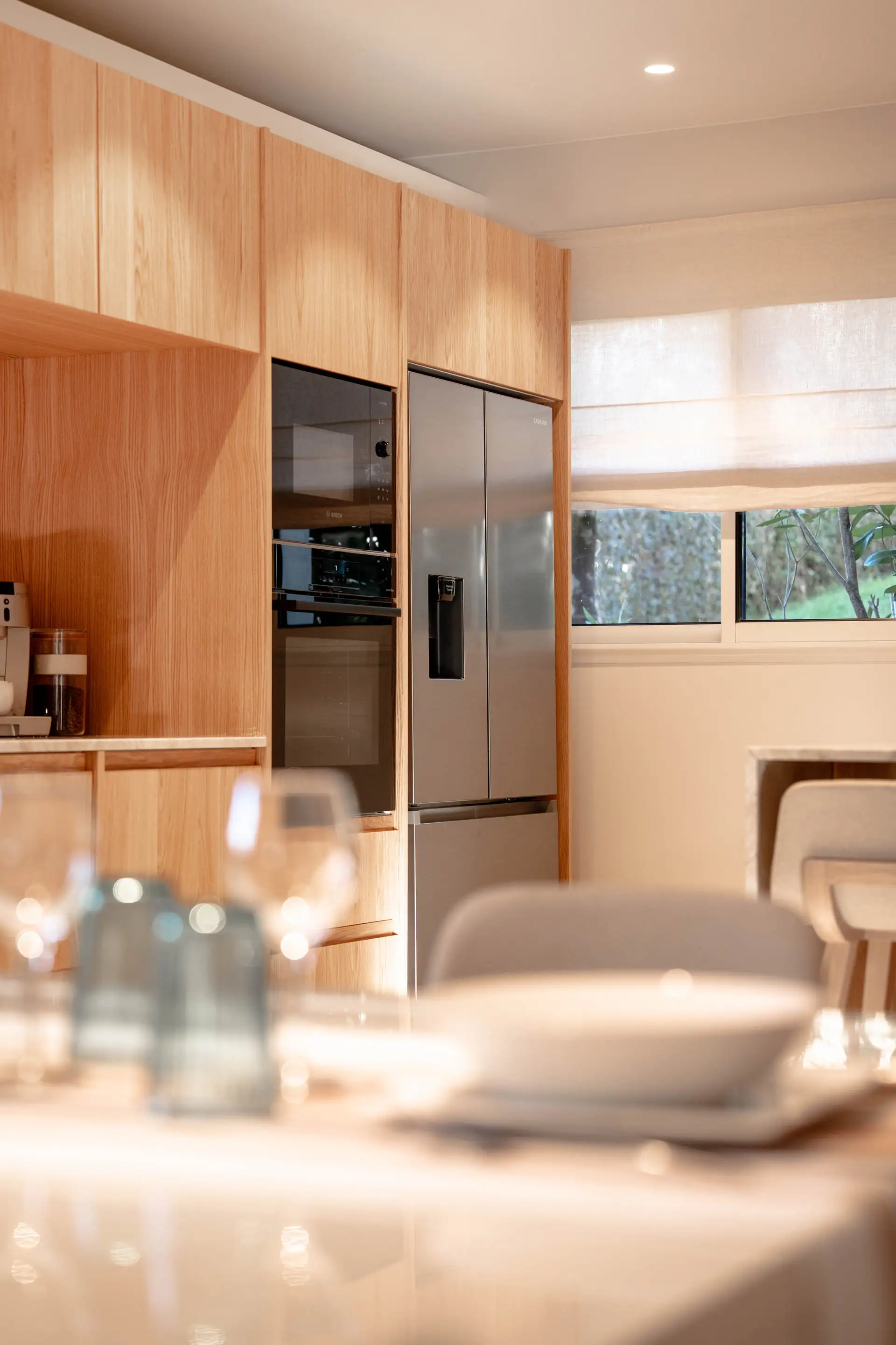 Meubles de cuisine en bois et table dressée au premier plan