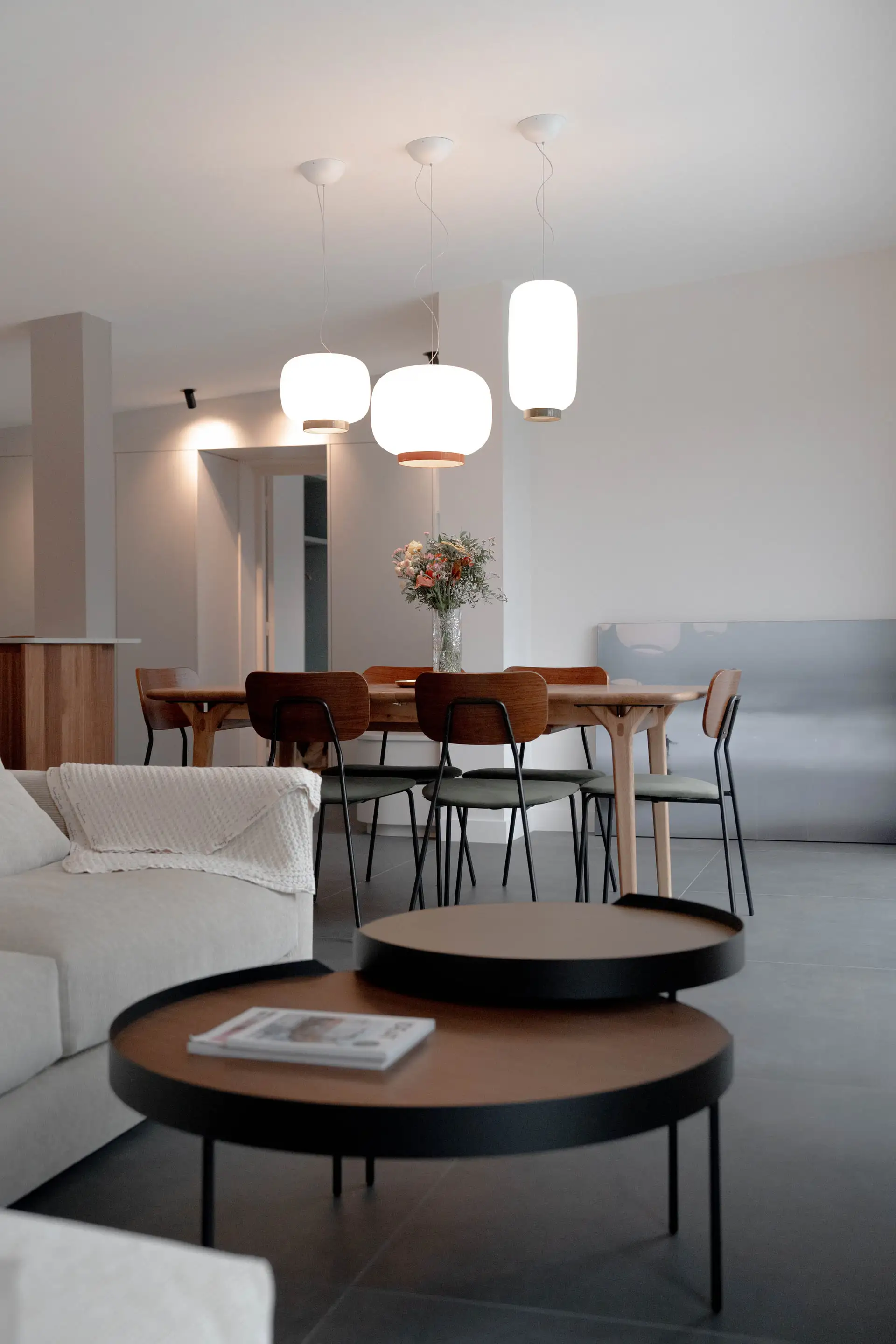 Séjour et salle à manger en enfilade, suspensions blanches et table basse ronde