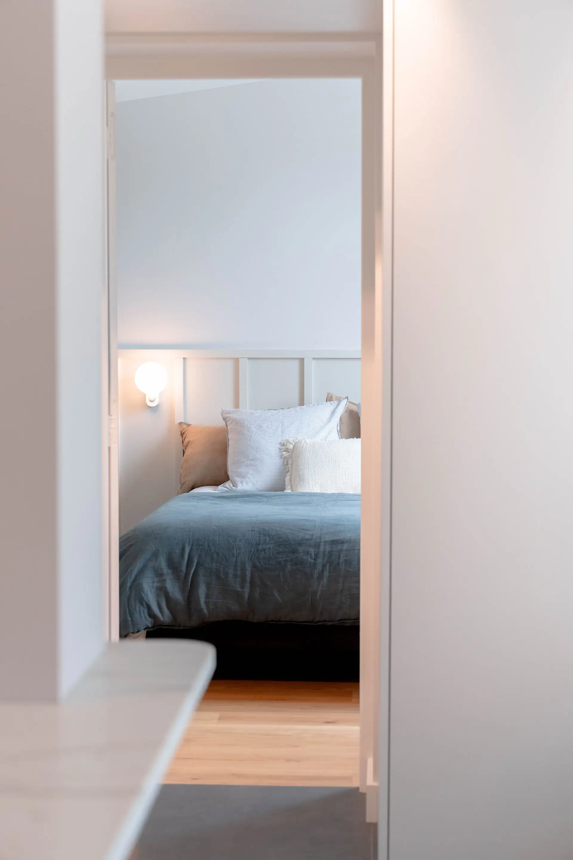 Chambre vue depuis le couloir par une porte en retrait