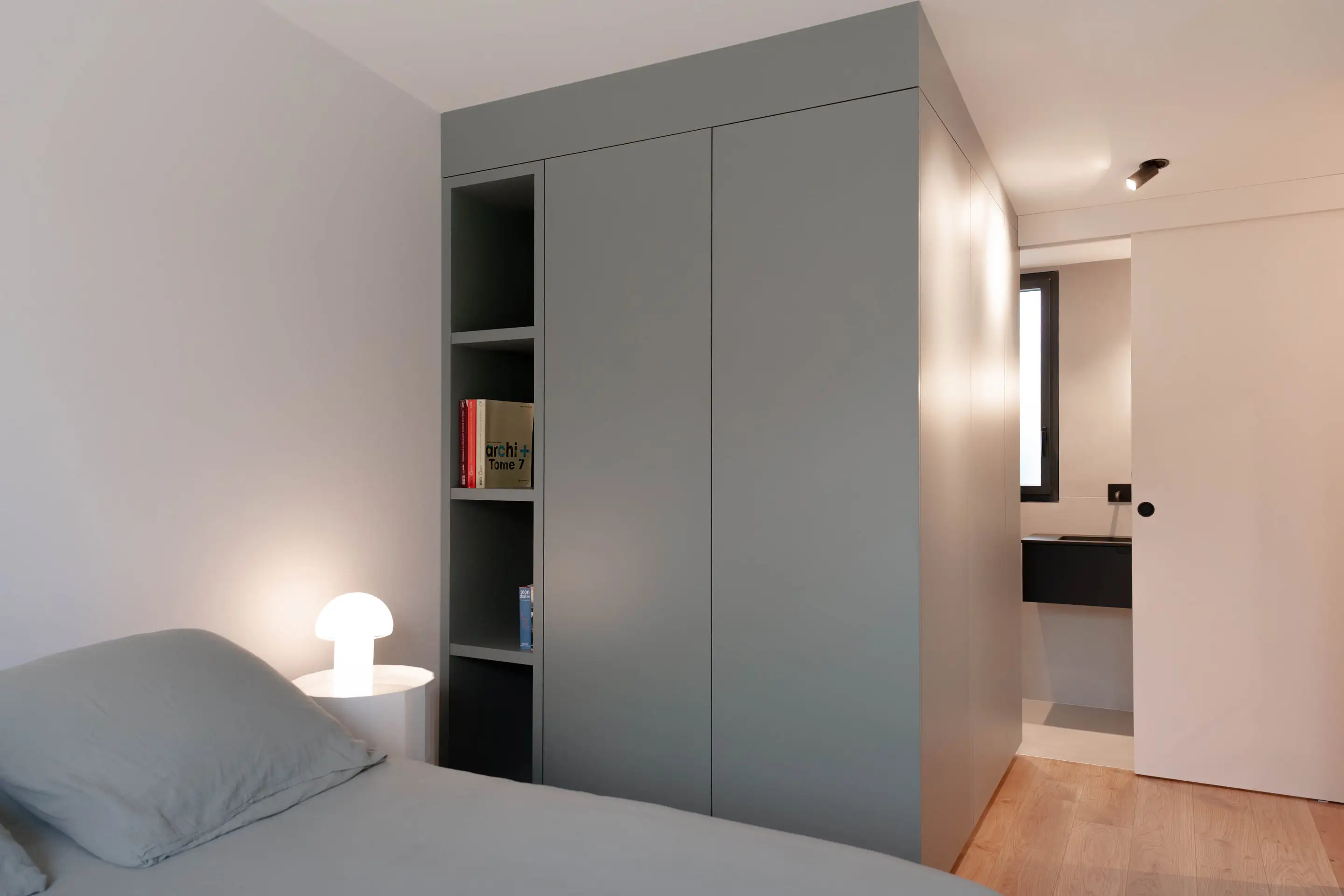 Chambre avec rangements gris-vert intégrés et lampe champignon
