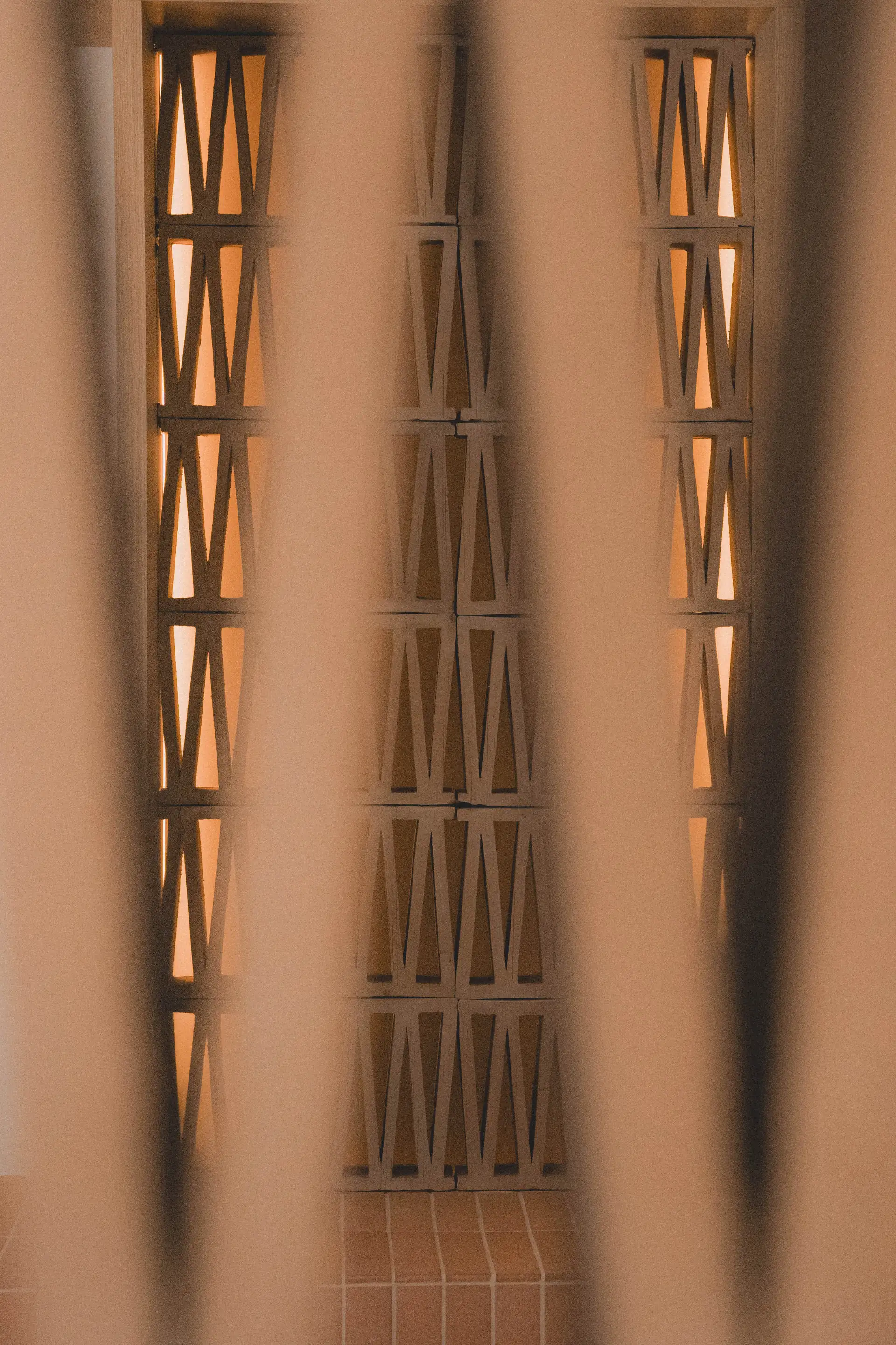 Motif triangulaire de la claustra en chêne éclairée par derrière