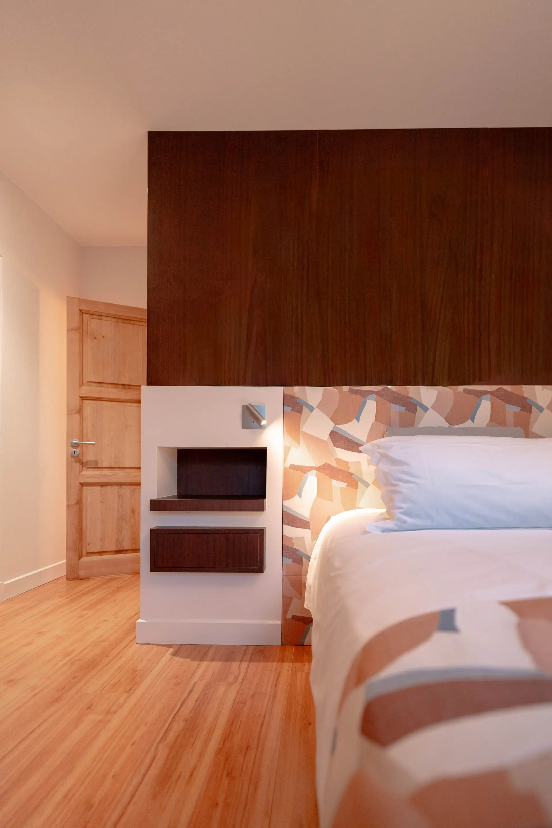 Chambre aux boiseries foncées et lit fait de blanc