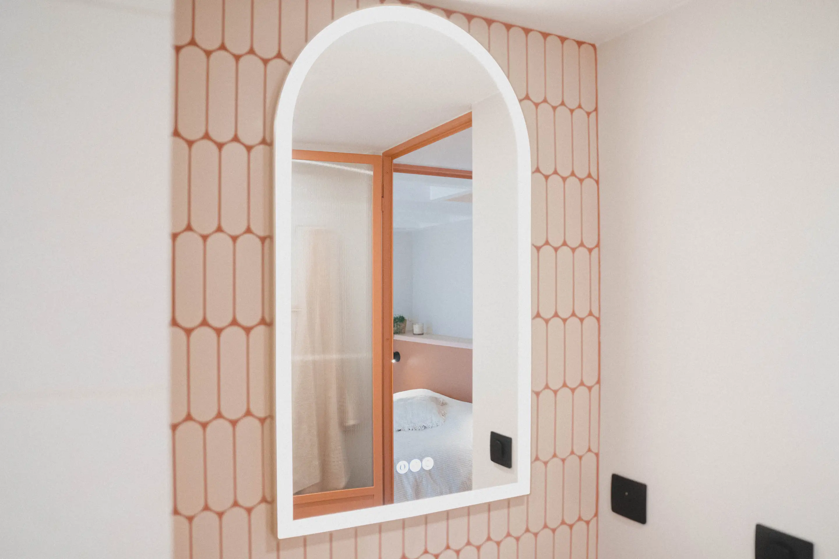 Miroir en arc lumineux sur une faïence à motifs d’arches terre cuite