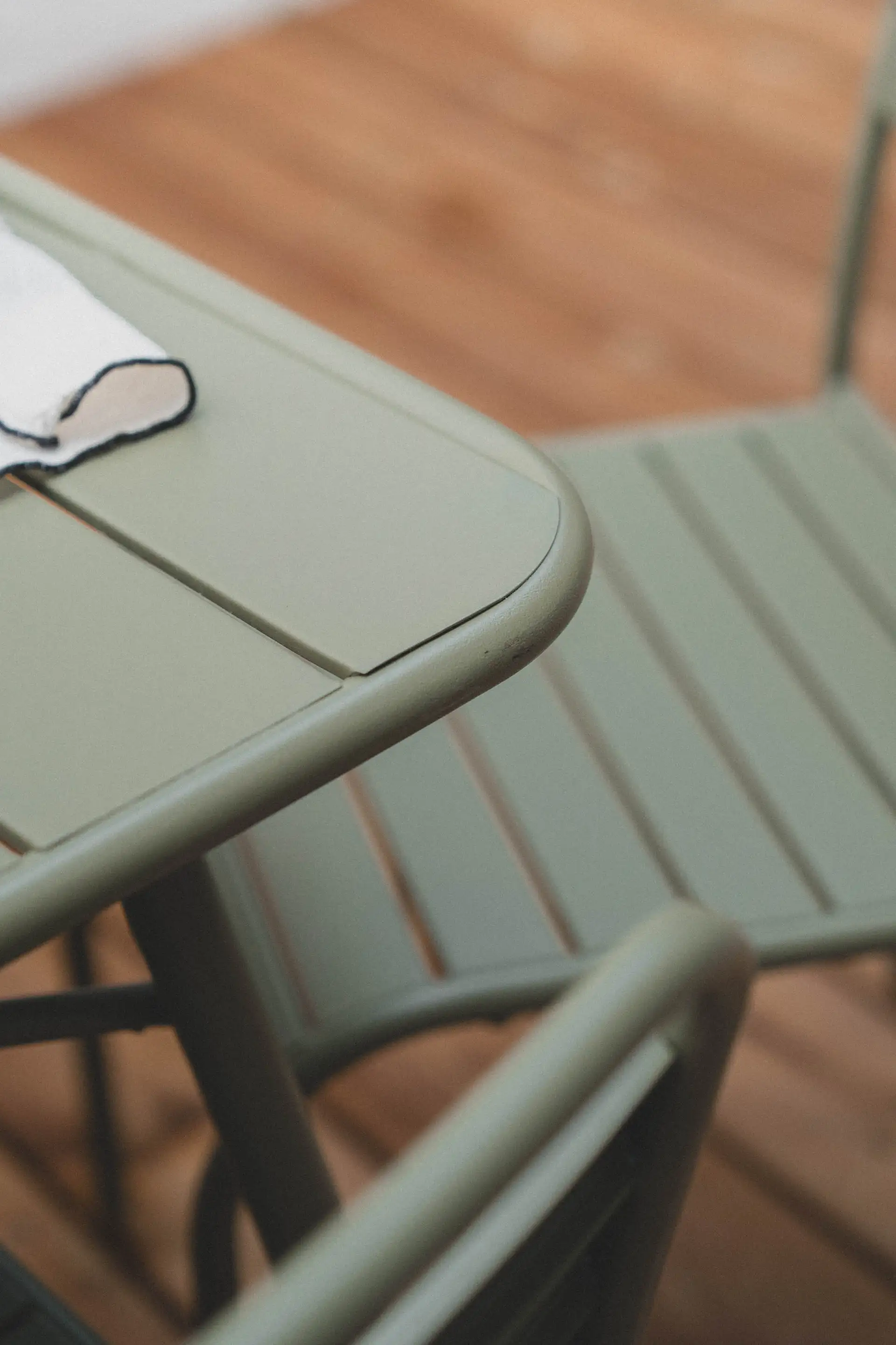 Chaise de jardin vert sauge sur le plancher en bois