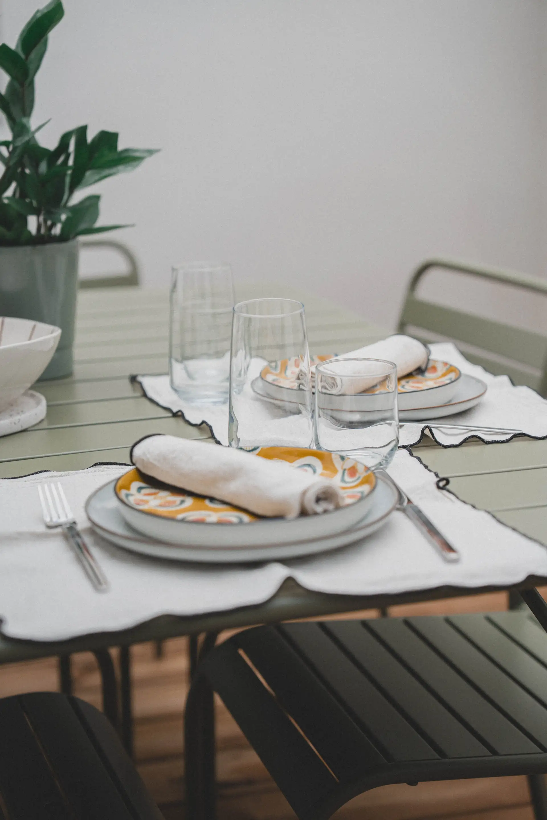 Assiettes à motifs et verres sur la table de la terrasse