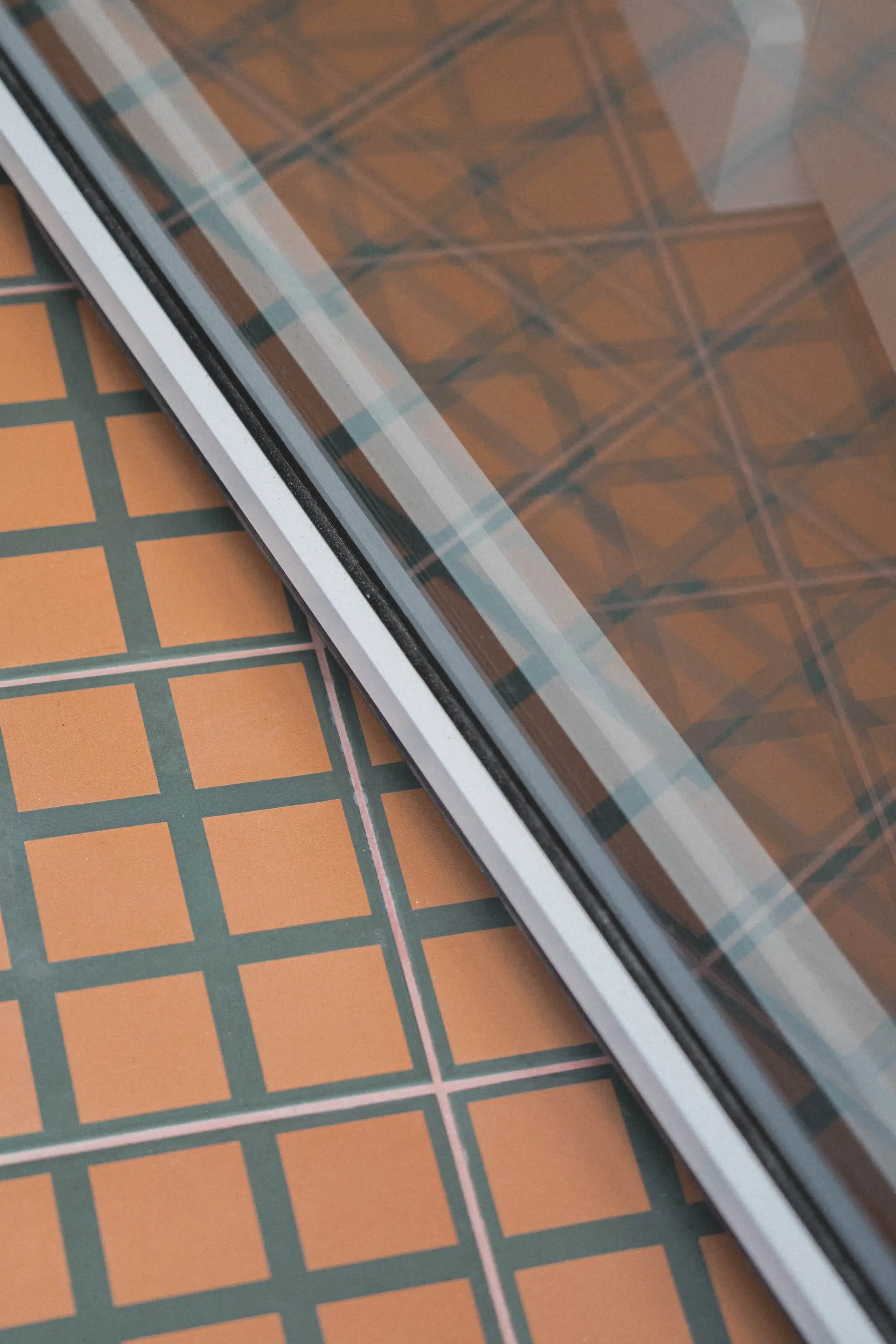 Carreaux terre cuite vus à travers la paroi de douche vitrée